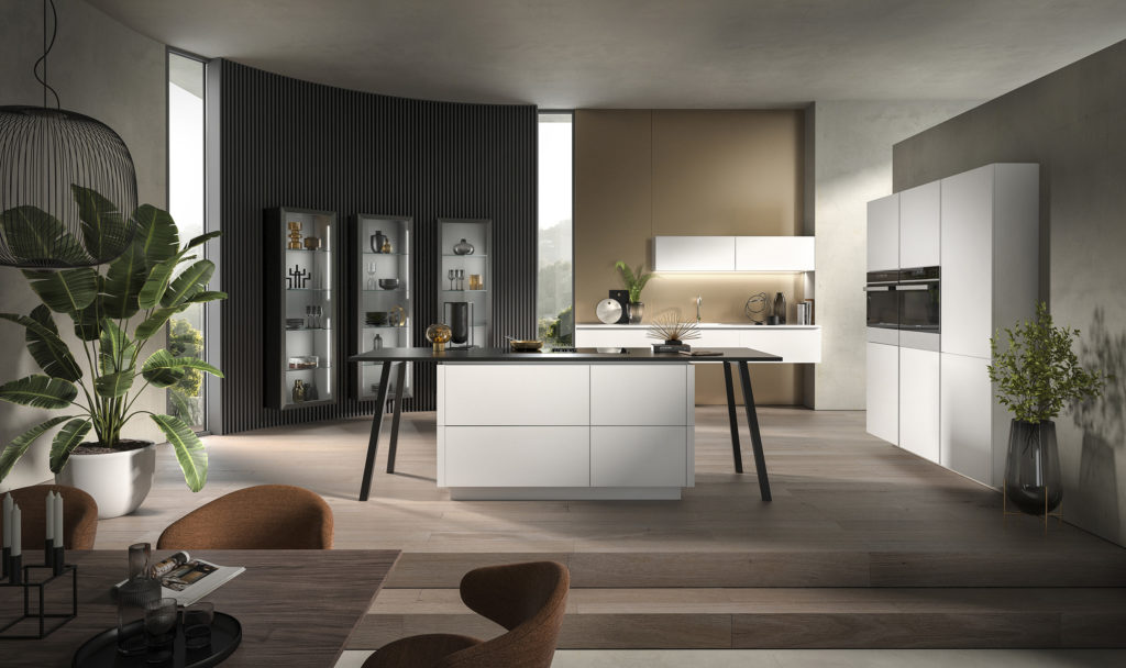 Cocina con isla en forma de mesa de estudio de acabado blanco mate y tirador push to open