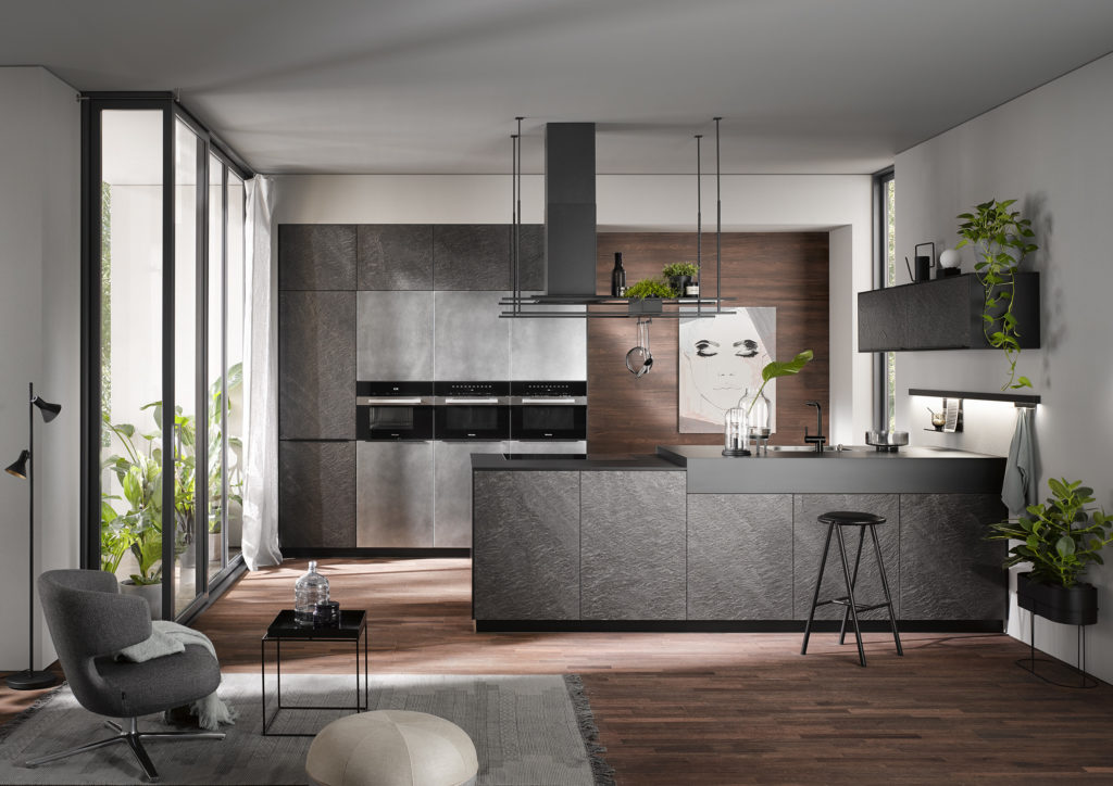 Cocina moderna con muebles en gris piedra y campana decorativa. Frontal de cocina en madera de roble natural.