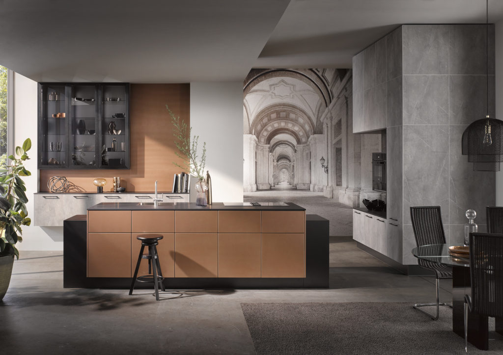 Cocina de estilo minimalista de acabados grises oscuros, negros y dorados.