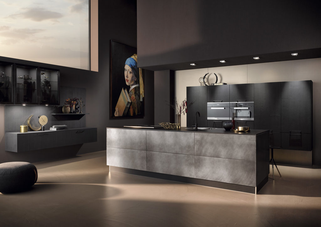 Cocina moderna de acabados oscuros y texturizados. Cocina abierta con isla oscura.