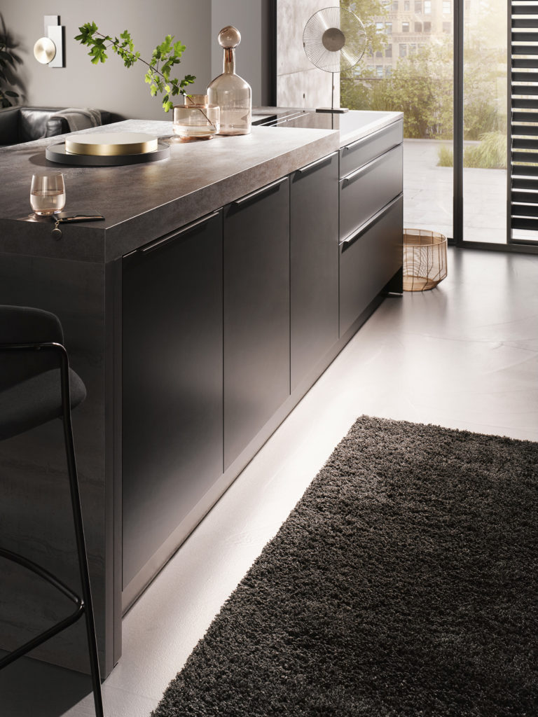 Isla de cocina con espacio de almacenaje con tirador integrado. Isla de cocina a doble altura para una postura ergonómica.