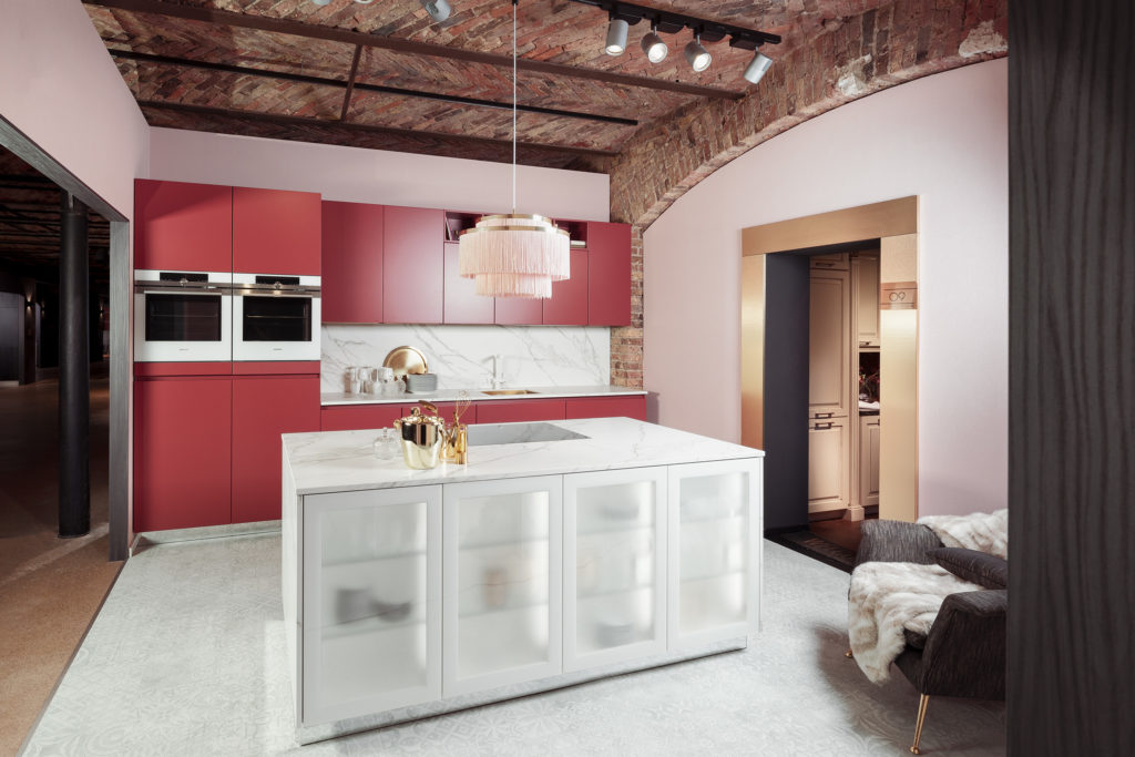 Cocina moderna blanca y roja. Cocina abierta con isla con vitrinas en blanco.