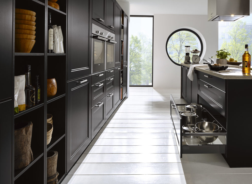 Cocina negro mate con muebles con molduras y tirador corto negro