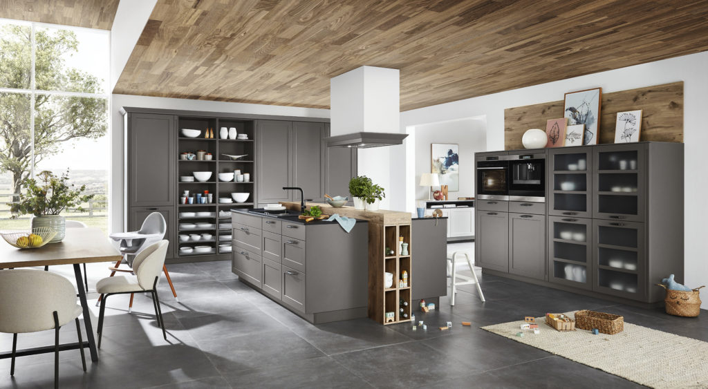 Cocina familiar de estilo clásico con muebles en gris oscuro con tiradores cortos y molduras. Cocina con vitrinas.