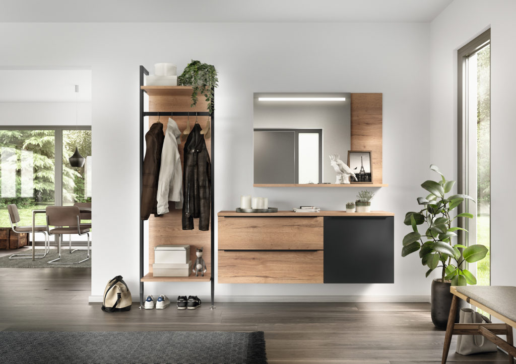 Recibidor abierto en casa moderna de acabado negro mate y madera natural